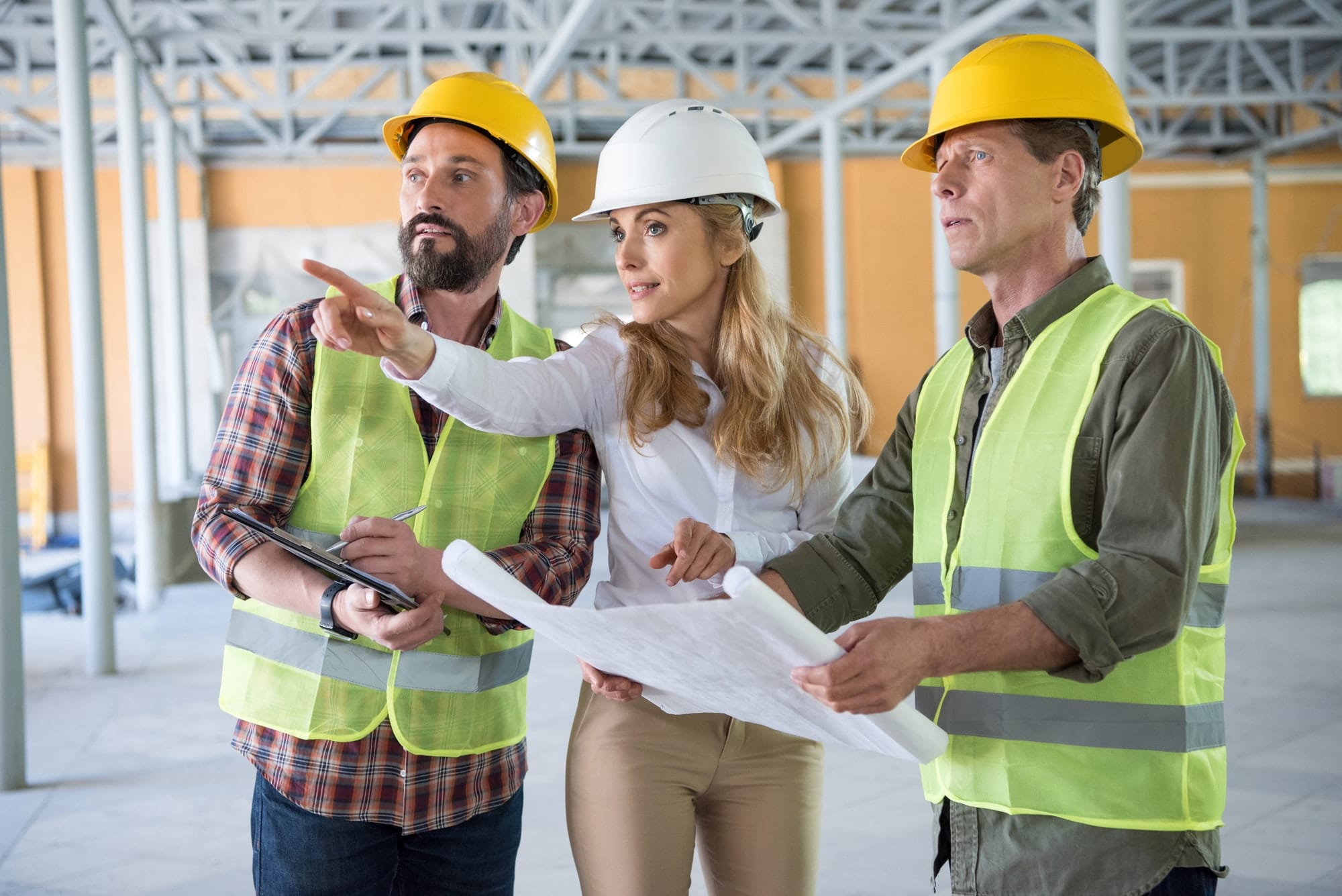 mature builders and contractor talking during work on construction site